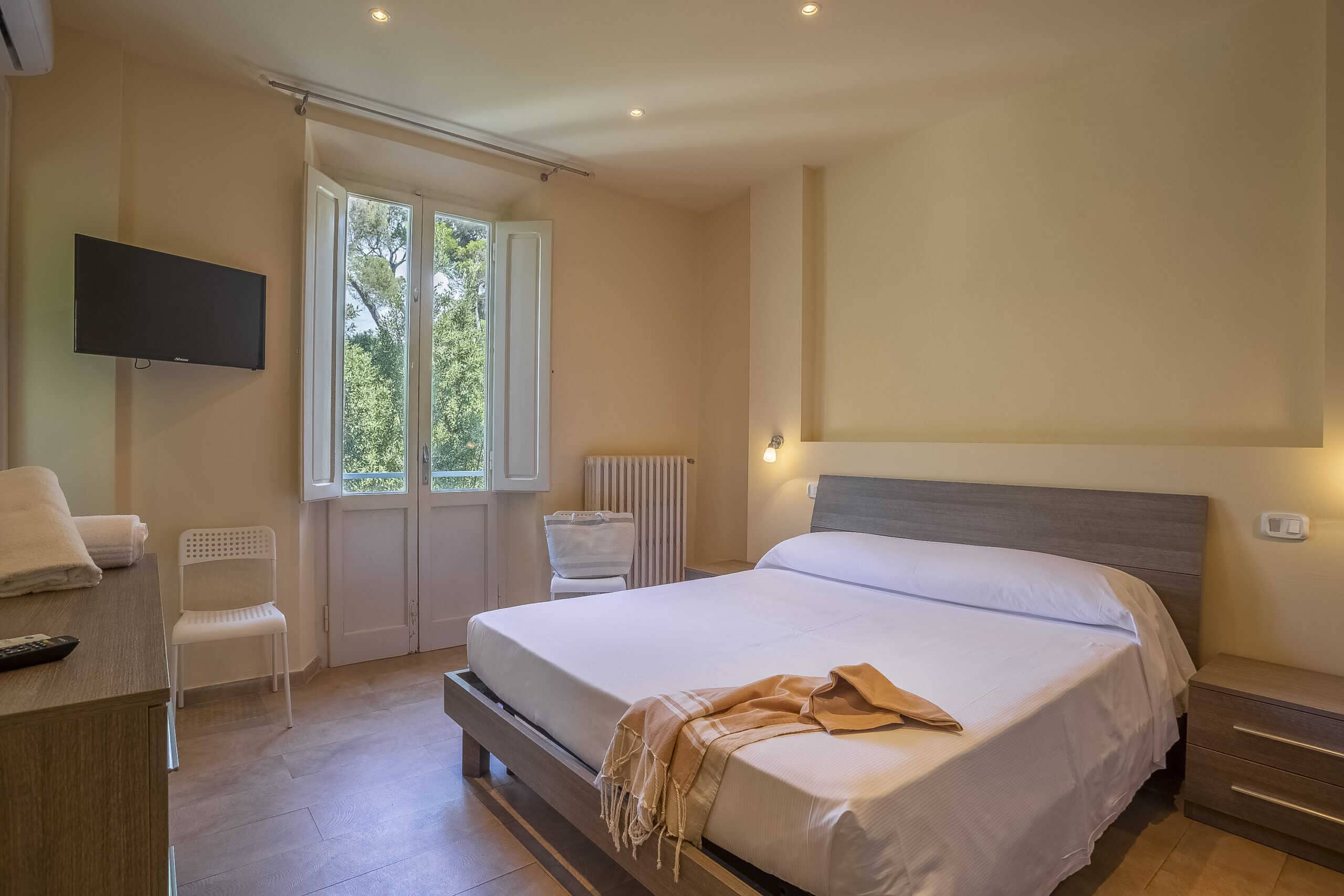 camera doppia economy dell'Hotel Guerrini con letto matrimoniale, televisore attaccato al muro e finestra