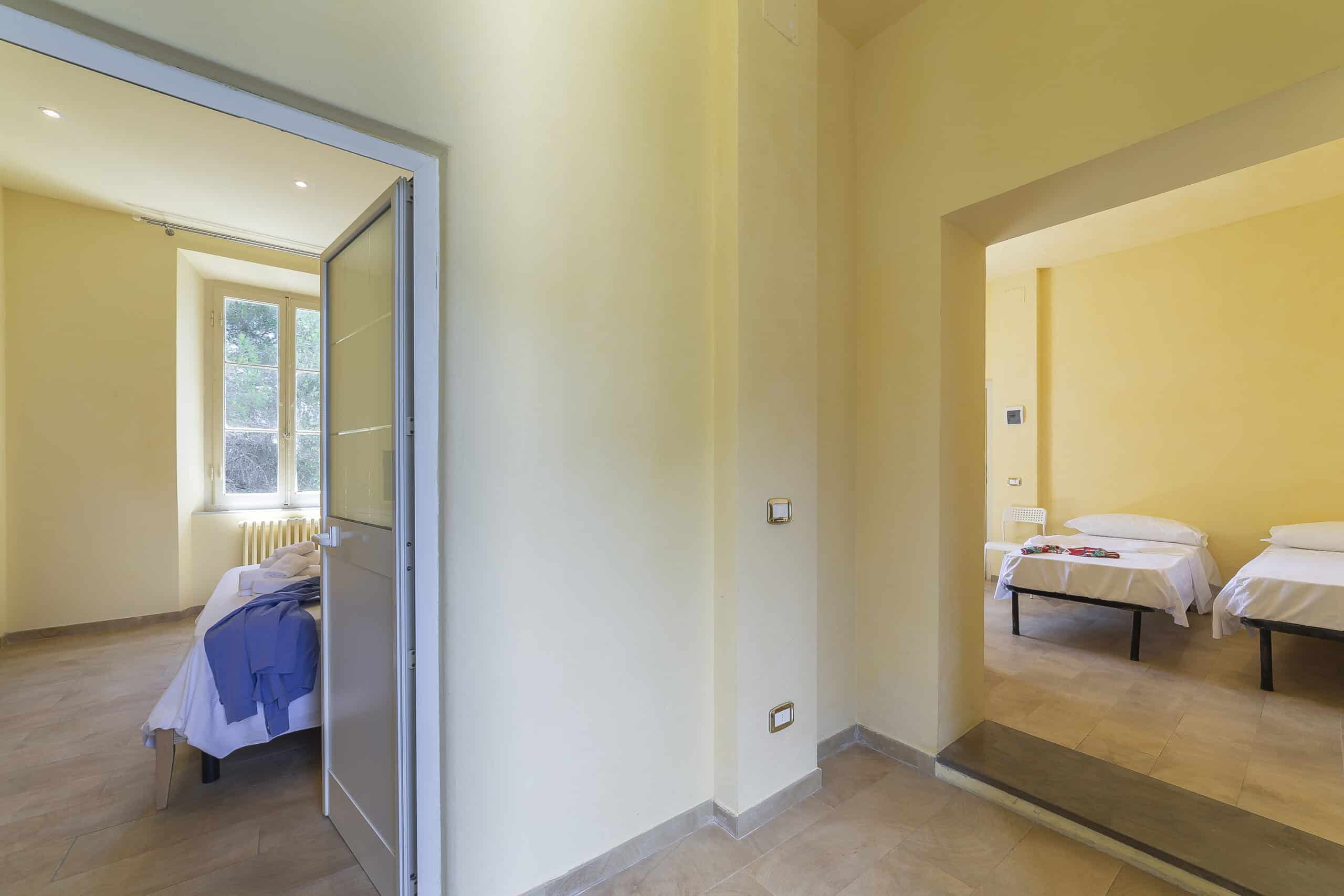 Due stanze una con letto matrimoniale ed un'altra con due letti singoli, camera Quadrupla Hotel Guerrini