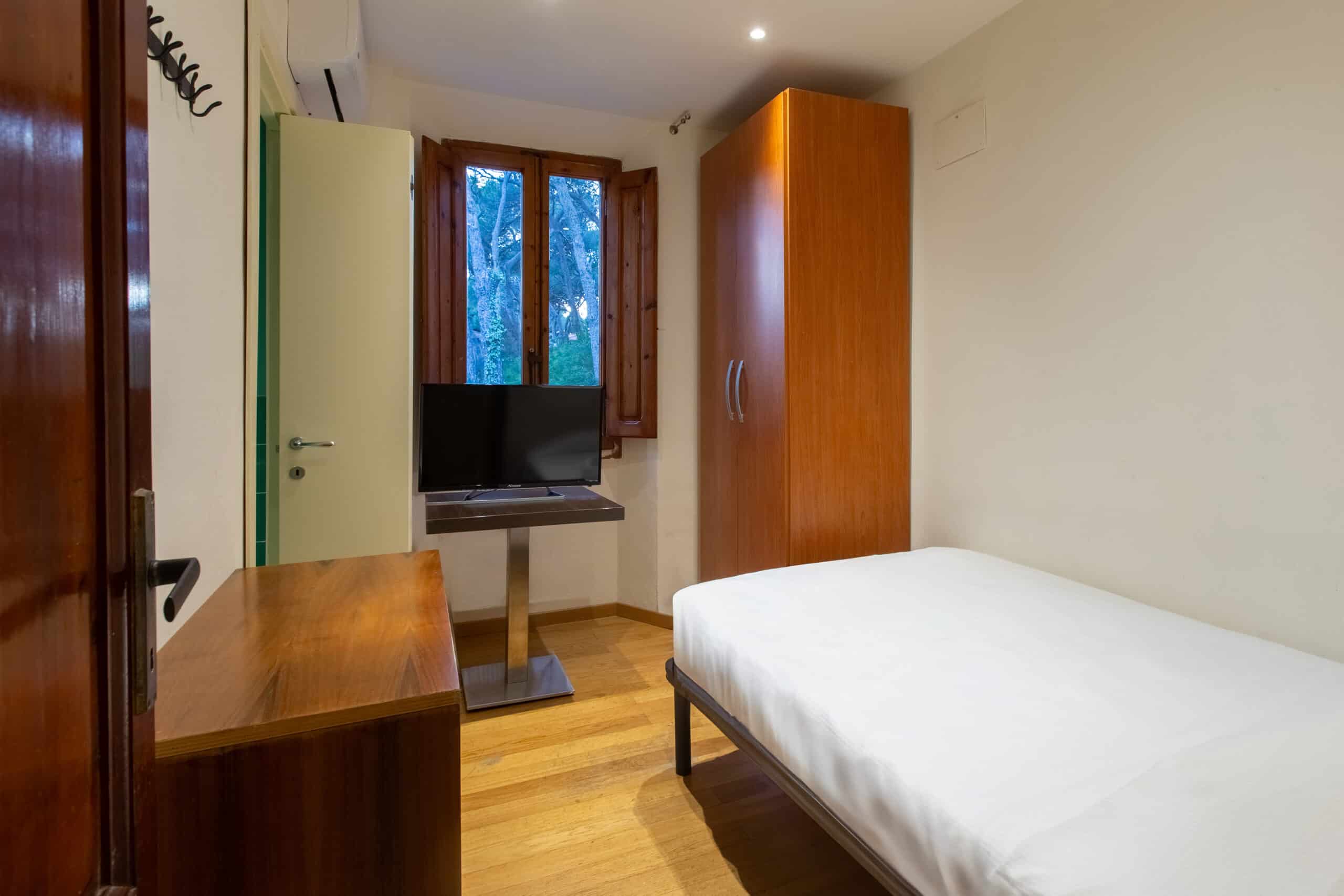 Camera singola dell'Hotel Guerrini con un letto singolo e televisione