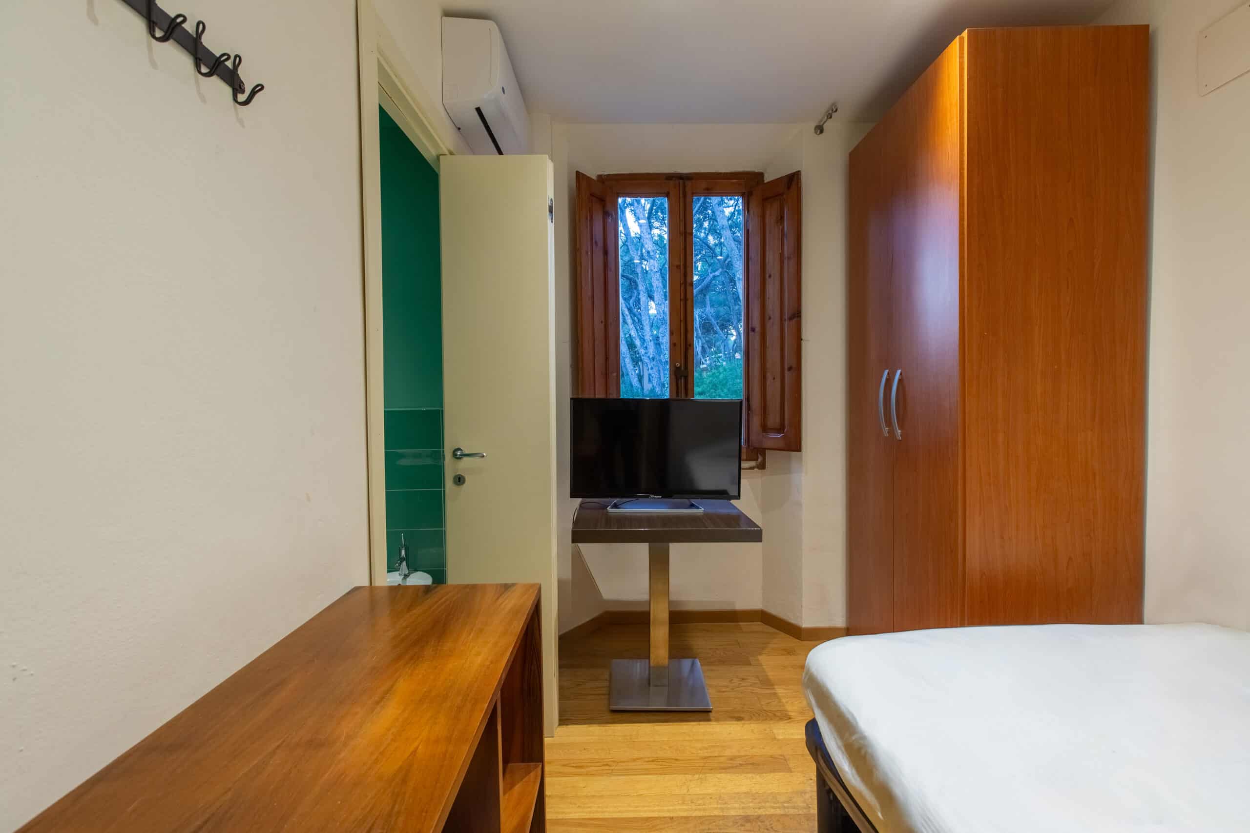 Camera singola dell'Hotel Guerrini con un letto singolo e televisione