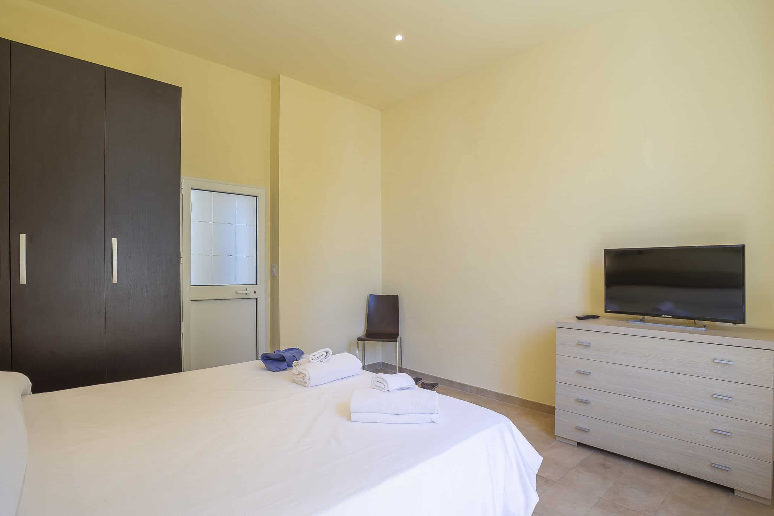 Letto matrimoniale, armadio e televisore Camera Tripla Hotel Guerrini